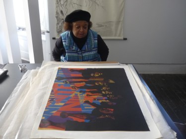 Barbara Jones-Hogu examining the first version of her print "Unite"